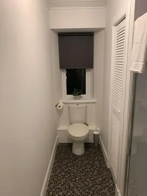 a bathroom with a toilet and a window at Apartment 39c in Oban