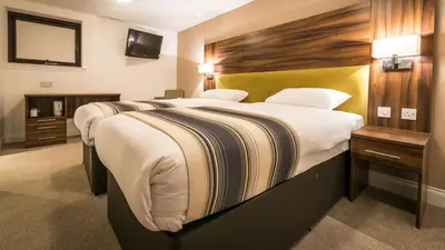 a hotel room with a large bed and a mirror at Livingston Lodge Hotel in Livingston