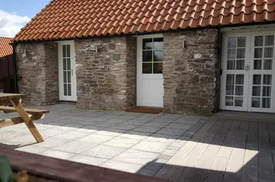 a house with a white door and a patio at Thornhill Lodge, Historic 4 Bed, 4 Ensuite in Stirling