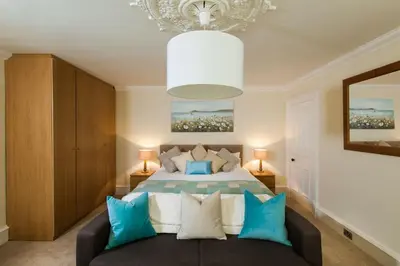 a bedroom with a bed with blue and white pillows at Thornhill House - Historic 5 Bedroom 5 Ensuite in Stirling