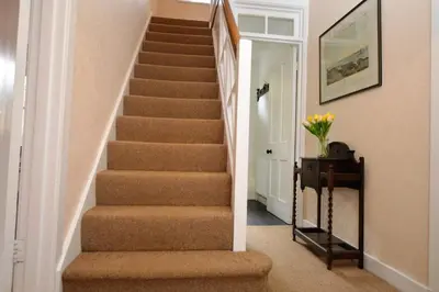 a staircase in a home with brown carpet at Rhoda`s Cottage in Creggans