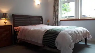 a bedroom with a bed and a window at North Lodge of Orchil in Braco