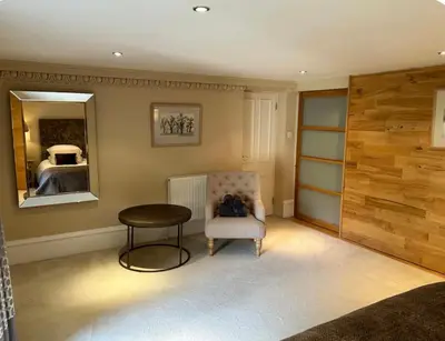 a room with a chair and a table and a mirror at Grand in the Park in Glasgow