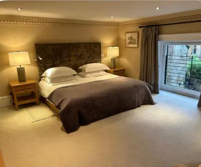 a bedroom with a large bed with two lamps and a window at Grand in the Park in Glasgow