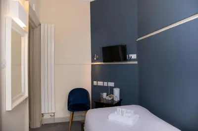 a bedroom with a bed and a blue wall at JOIVY Haymarket in Edinburgh