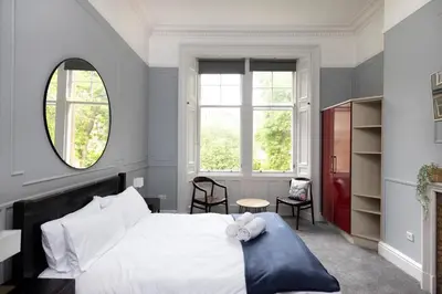 a bedroom with a white bed and a mirror at JOIVY Haymarket in Edinburgh