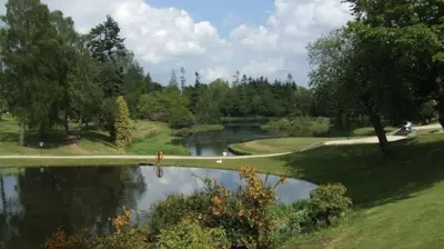 a golf course with a pond in the middle of a park at Luxury 2Bedroom Lodge in Auchterarder