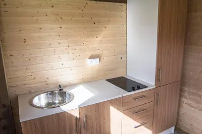 a bathroom with a sink and wooden walls at Little Lochan Lodge in Glenfarg