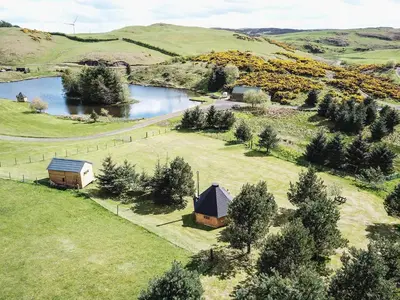 an aerial view of a farm with a lake and a barn at Little Lochan Lodge in Glenfarg