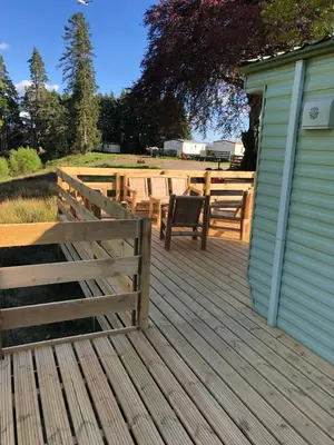 a wooden deck with a fence and a table at Lyndhurst 28 in Dunoon