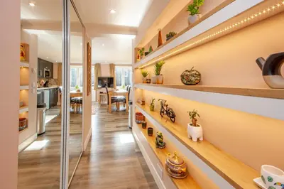 a home hallway with shelves with plants and a kitchen at Mandarin Premier Apartments C - studio apt in Oban