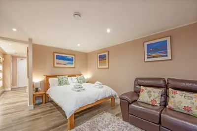 a bedroom with a bed and a couch at Mandarin Premier Apartments C - studio apt in Oban