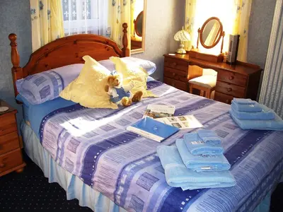 a teddy bear laying on top of a bed at Sunnyside B&B in Balloch