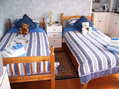 two beds with teddy bears sitting on them in a bedroom at Sunnyside B&B in Balloch