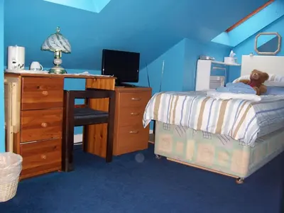 a bedroom with a bed and a desk with a teddy bear on it at Sunnyside B&B in Balloch