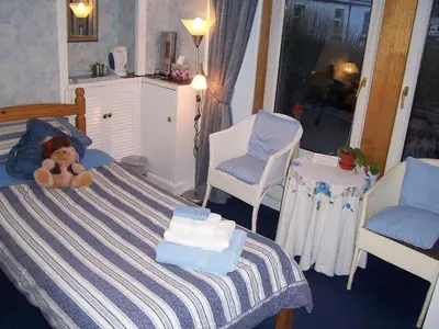 a bedroom with a teddy bear sitting on a bed at Sunnyside B&B in Balloch