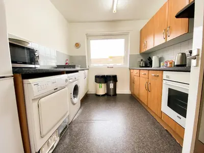 a kitchen with a washer and dryer and a window at Glasgow Green Park Home in Glasgow