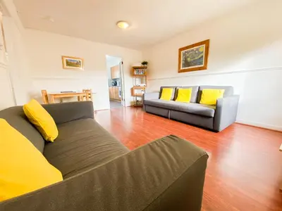 a living room with two couches and yellow pillows at Glasgow Green Park Home in Glasgow
