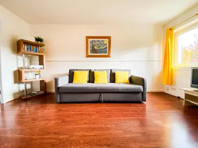 a living room with a couch with two yellow pillows at Glasgow Green Park Home in Glasgow