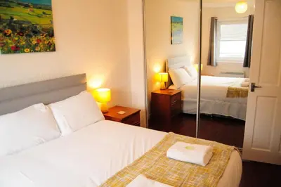 a hotel room with a bed and a mirror at Glasgow Green Park Home in Glasgow