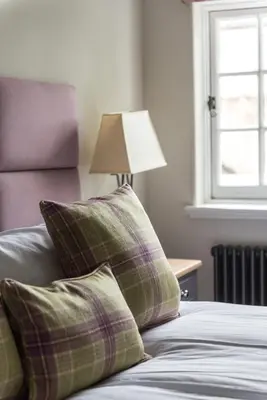 a bedroom with a bed with two pillows and a lamp at Amazing penthouse, stunning views, Castle 2 mins in Edinburgh