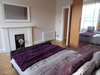 a living room with a couch and a fireplace at WEST END - Stunning, spacious, 3 bedroom, main door flat with private parking in Glasgow