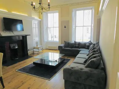 a living room with a couch and a coffee table at WEST END - Stunning, spacious, 3 bedroom, main door flat with private parking in Glasgow