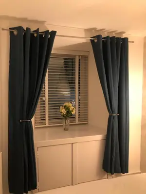 a window with black curtains and a vase of flowers at The Nook - Coorie Doon in Ayr