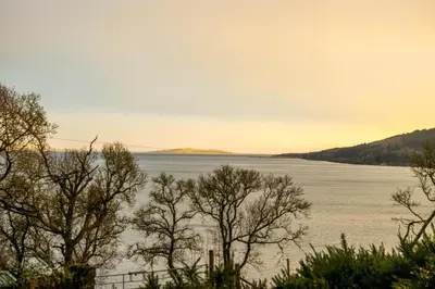 a view of a lake with trees in the foreground at The Tregortha B&B in Tighnabruaich