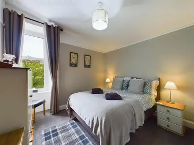 a bedroom with a large bed and a window at The Tregortha B&B in Tighnabruaich