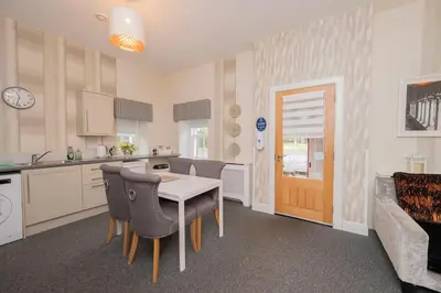 a kitchen and dining room with a table and chairs at The Lodge House Callander in Callander
