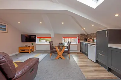a kitchen with a couch and a table in a room at Mandarin Premier Apartments B - Loft studio apt in Oban