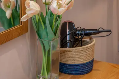 a vase with flowers in it on a table at Mandarin Premier Apartments B - Loft studio apt in Oban