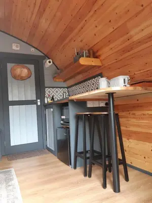 a kitchen with a counter top and a wooden ceiling at Coe Pod, West Highland Way Holidays in Kinlochleven