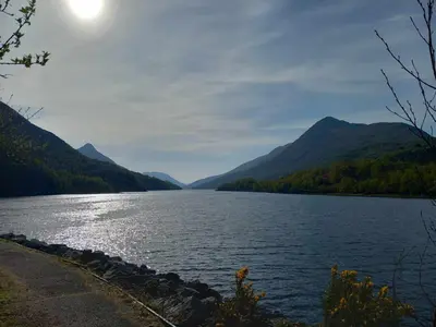 a view of a lake with mountains in the background at Coe Pod, West Highland Way Holidays in Kinlochleven