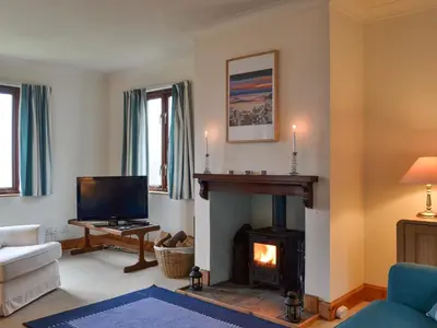a living room with a fireplace and a tv at Tigh An Aighear in Arduaine