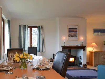 a dining room with a table and a fireplace at Tigh An Aighear in Arduaine