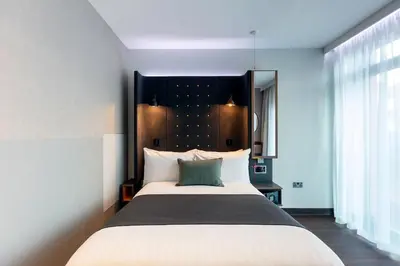 a bedroom with a large bed with a black headboard at Point A Hotel Edinburgh Haymarket in Edinburgh