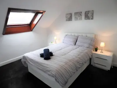 a bedroom with a white bed with a window at 4 Bed Apartment, Paisley - Near GLA Airport in Paisley