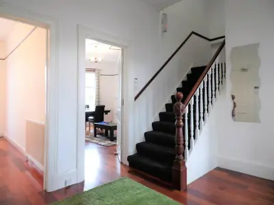 a staircase in a home with a green rug at 4 Bed Apartment, Paisley - Near GLA Airport in Paisley