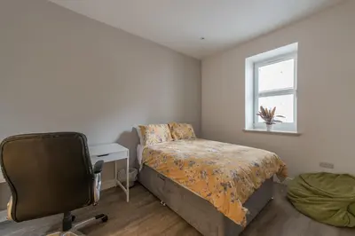 a bedroom with a bed and a desk and a chair at Haymarket Spacious 3 Bedroom Street Level in Edinburgh