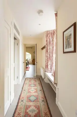 a hallway with a rug on the floor and a window at Old Leckie Farmstay in Stirling