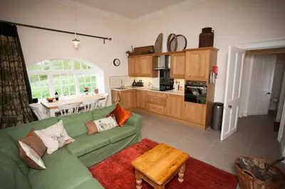 a living room with a green couch and a table at Old Leckie Farmstay in Stirling