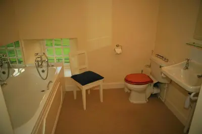a bathroom with a tub and a toilet and a sink at Arndean Cottages in Dollar