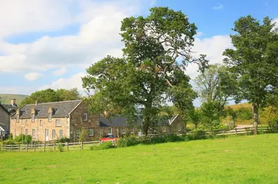 a large house in the middle of a field at Arndean Cottages in Dollar