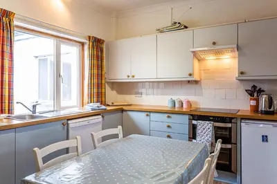 a small kitchen with a table and a sink at Beach Front Flat, Brodick in Brodick