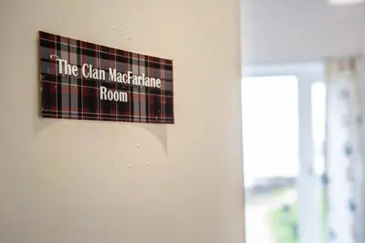 a plaid sign on the wall of a room at Beach Front Flat, Brodick in Brodick