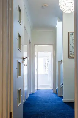 a hallway with a blue carpet and a door at Beach Front Flat, Brodick in Brodick