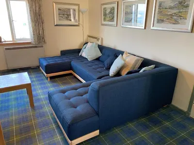 a blue couch sitting in a living room at Beach Front Flat, Brodick in Brodick
