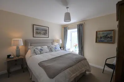 a bedroom with a large bed and a window at No 1 Ramageton at Carnell Estates in Hurlford